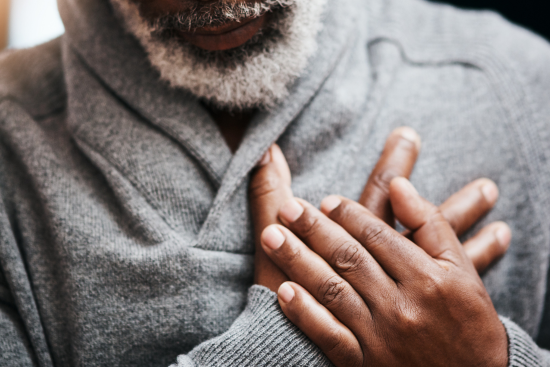 man with hands to chest