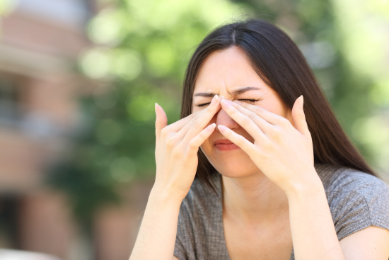 woman squeezing her nose