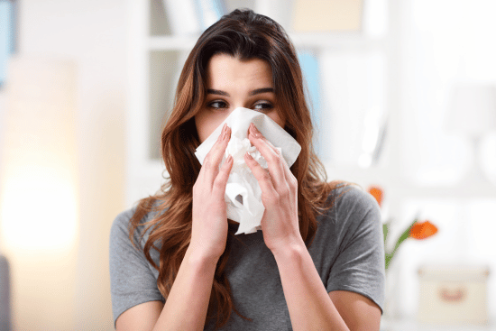 image of woman holding tissue up to her nose
