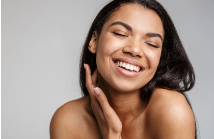 picture of smiling woman applying cream to treat acne