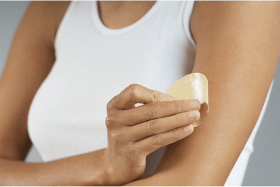 Woman applying Lidocaine Patch for Pain Relief