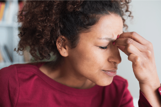 Woman suffering sinusitis (nasal congestion)